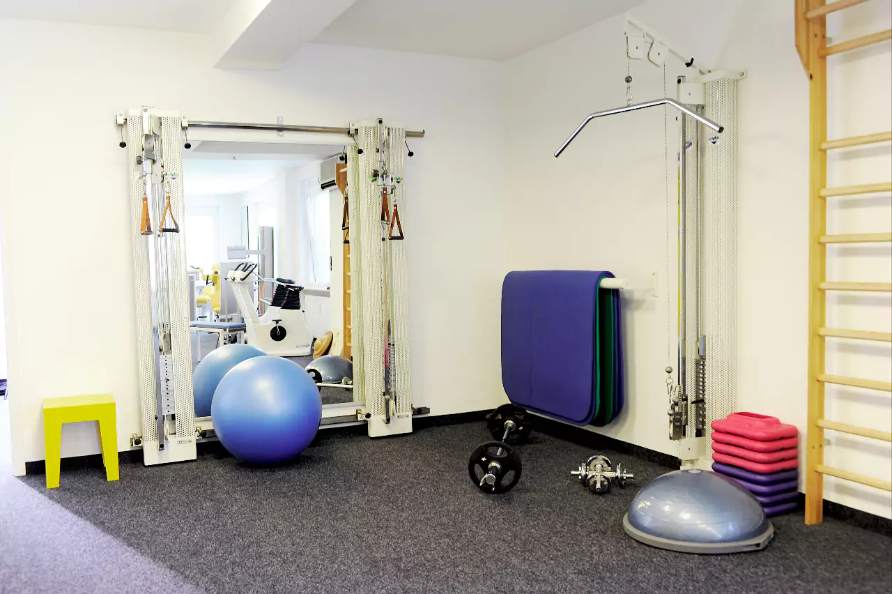 Behandlungszimmer mit Sprossenwand, Hanteln, Gymnastikball, Hometrainer