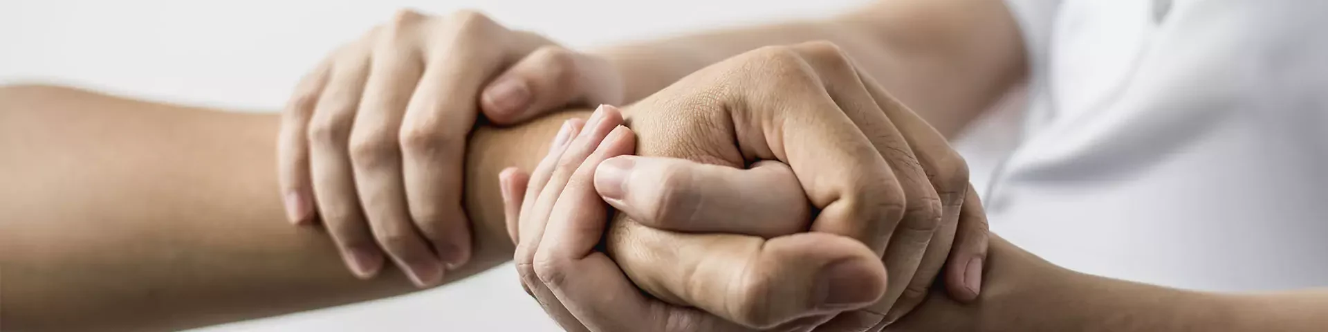 Physiotherapeut behandelt das Handgelenk eines Patienten durch leichte Massage