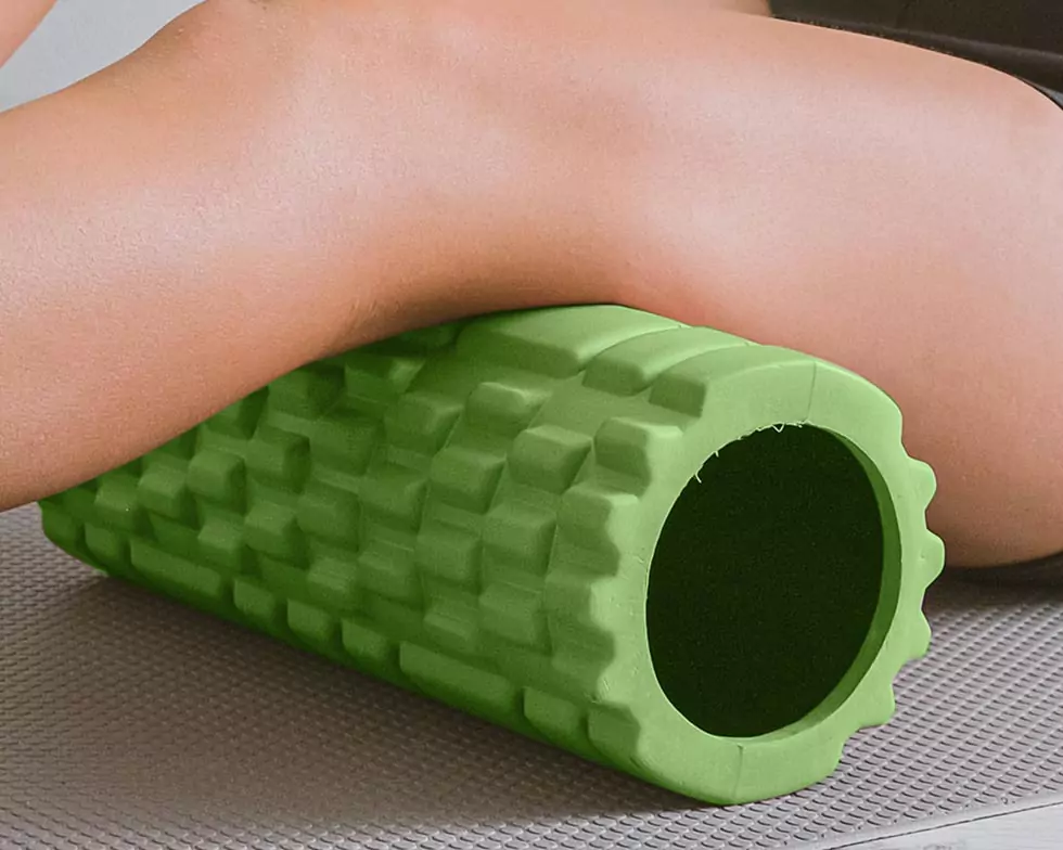 Nahaufnahme einer Frau, die mithilfe einer Blackroll die Beinmuskulatur stärkt