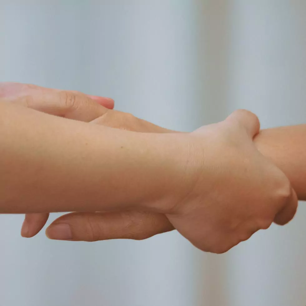 Therapeut massiert die Hand und den Arm einer Patientin