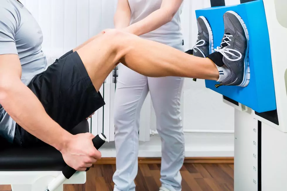 Patient macht Übungen an der Beinpresse zur Stärkung der Beinmuskulatur